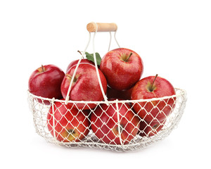 Metal basket of ripe juicy red apples with leaf on white background