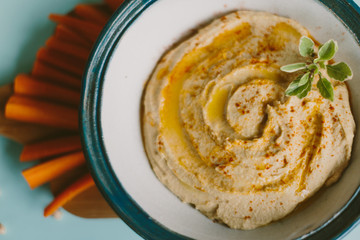 close up of homemade hummus on blue background