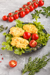 minced chicken cutlets with lettuce, tomatoes and herbs on a gray concrete background. side view.