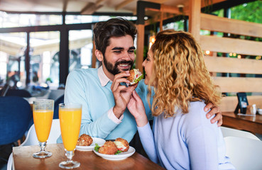 Young couple sitting in a cafe, having breakfast. Love, dating, food, lifestyle concept