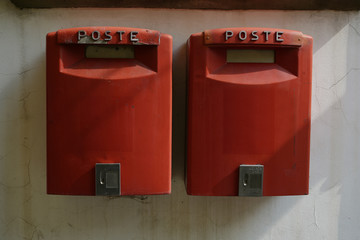two red mailboxes on a wall from the italian post in tuscany, italy