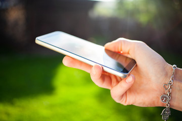 woman's hands using smartphone outdoors - online communication