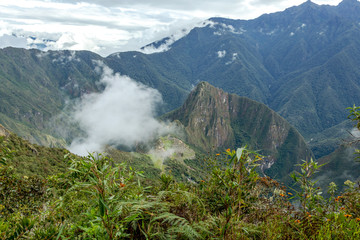 Fototapeta na wymiar Huayna Picchu, or Wayna Pikchu, mountain in clouds rises over Machu Picchu Inca citadel, lost city of the Incas