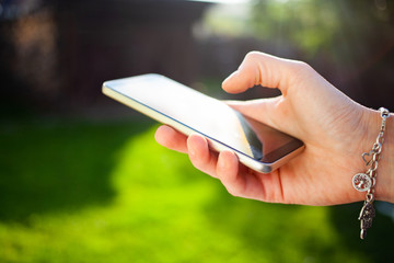 woman's hands using smartphone outdoors - online communication