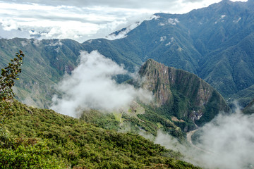 Aerial view of Machu Picchu Inca citadel in the clouds, located on a mountain ridge above the Sacred Valley