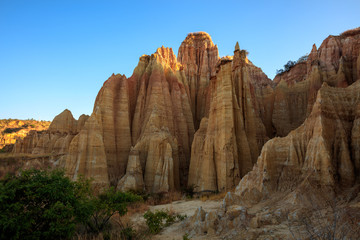 Earth Forest of Yuanmou in Yunnan Province, China - Exotic earth and sandstone formations glowing in the sunlight. Naturally formed pillars of rock and clay with unique erosion patterns. China Travel