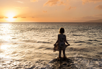 Silhouette of a girl on a beach at sunset in Hawaii
