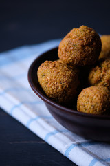 Classic hummus balls in a clay plate on a wooden table. National, vegetarian dish. General form.