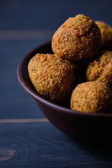 Classic hummus balls in a clay plate on a wooden table. National, vegetarian dish. General form.