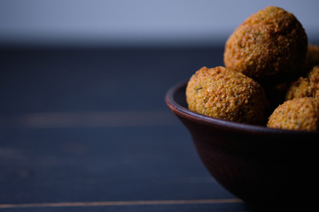 Classic hummus balls in a clay plate on a wooden table. National, vegetarian dish. General form.