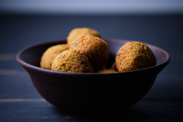 Classic hummus balls in a clay plate on a wooden table. National, vegetarian dish. General form.