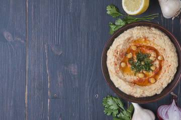 Hummus with hot pepper and ingredients laying out for the background. Place for text. Retro style.