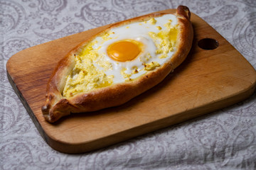 Adjar khachapuri on a wooden board.