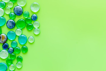 Bright stones on green background top view mock up