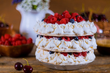 Pavlova cake of three layers of meringue, whipped cream and berries