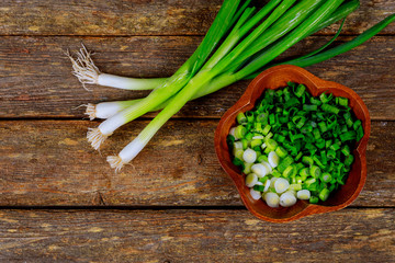 Scallion on wood background and cut onoin wood plate