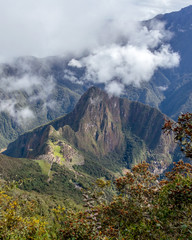 Aerial view of Machu Picchu Inca citadel in the clouds, located on a mountain ridge above the Sacred Valley
