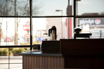 View of coffee shop self service counter where patrons can add milk, cream, sugar, half and half or...
