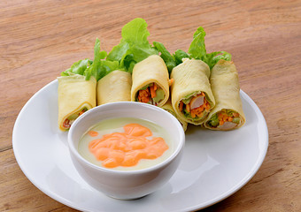 Salad egg roll in white plate on wooden background