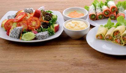 vegetable salad and Salad roll in white plate on wooden background