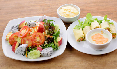 vegetable salad and Salad roll in white plate  on wooden background