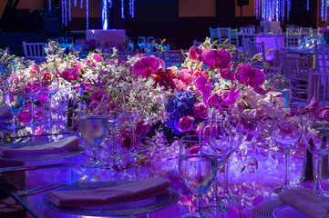 Obraz na płótnie Canvas Flower bouquet with roses on glass luxury dinner table