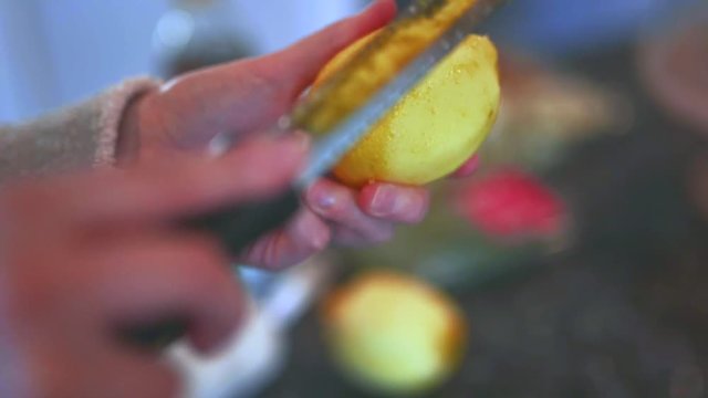 Female home cook zesting a freshly picked organic lemon in the kitchen.