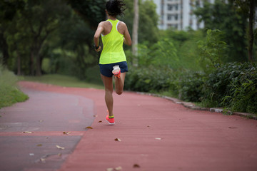 Fitness sporty woman jogger running at outdoors jogging track in park