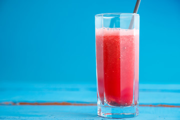 smoothies,freshly squeezed watermelon juice in a transparent glass on a blue wooden background