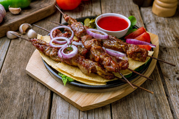 platter of different kebabs on wooden background