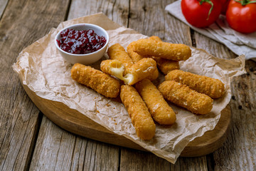 fried Cheese sticks with berry sause on the board