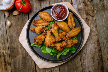 chicken wings in barbecue sauce on wooden background