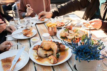 Group of family and friends share foods and having lunch time outdoor together on wooden table in sunny day