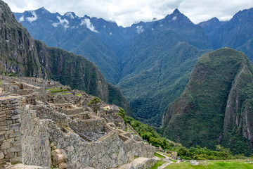 Fototapeta na wymiar Abandoned ruins of Machu Picchu Incan citadel, the maze of terraces and walls rising out of the thick undergrowth, Peru