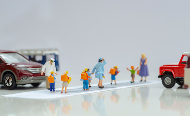 Illustrative editorial - Miniature toys school kids walk on cross road bar code - school children road safety concept.