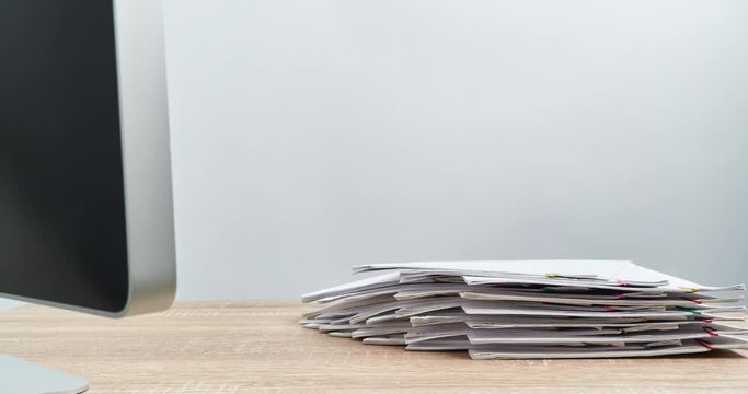 Pile overload document with computer on wood table time lapse