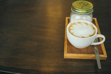 Coffee cup and coffee beans on wooden table  in cafe