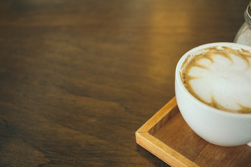 Coffee cup and coffee beans on wooden table  in cafe