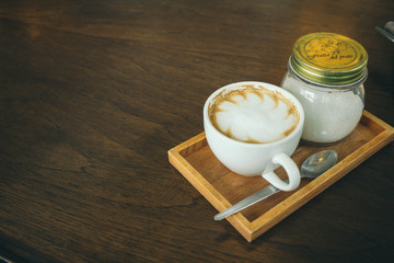 Coffee cup and coffee beans on wooden table  in cafe