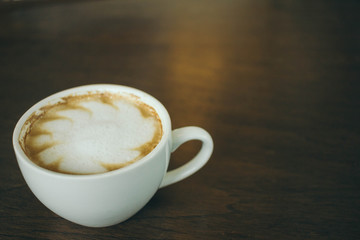 Coffee cup and coffee beans on wooden table  in cafe