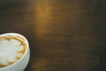 Coffee cup and coffee beans on wooden table  in cafe