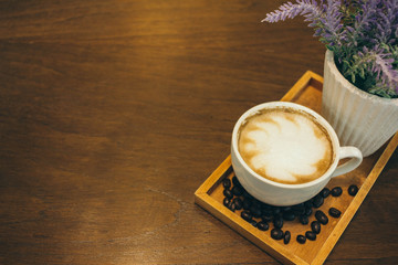 Coffee cup and coffee beans on wooden table  in cafe