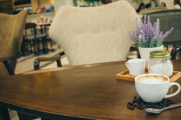 Coffee cup and coffee beans on wooden table  in cafe