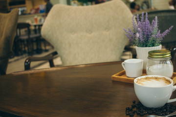 Coffee cup and coffee beans on wooden table  in cafe