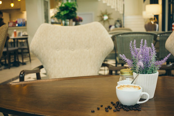 Coffee cup and coffee beans on wooden table  in cafe