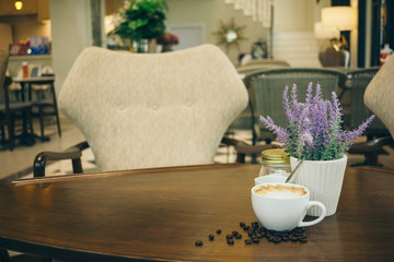 Coffee cup and coffee beans on wooden table  in cafe