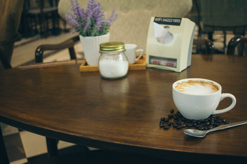 Coffee cup and coffee beans on wooden table  in cafe