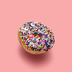 Funny shock face chocolate donut with sprinkles on a pink background, creative minimal food concept, doughnut isolated on colorful background with clipping path