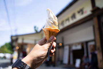 Ice cream in the hand held up in the sky