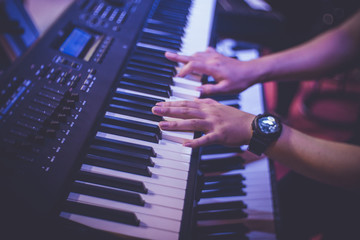 Musician's hands playing keyboard in concert.